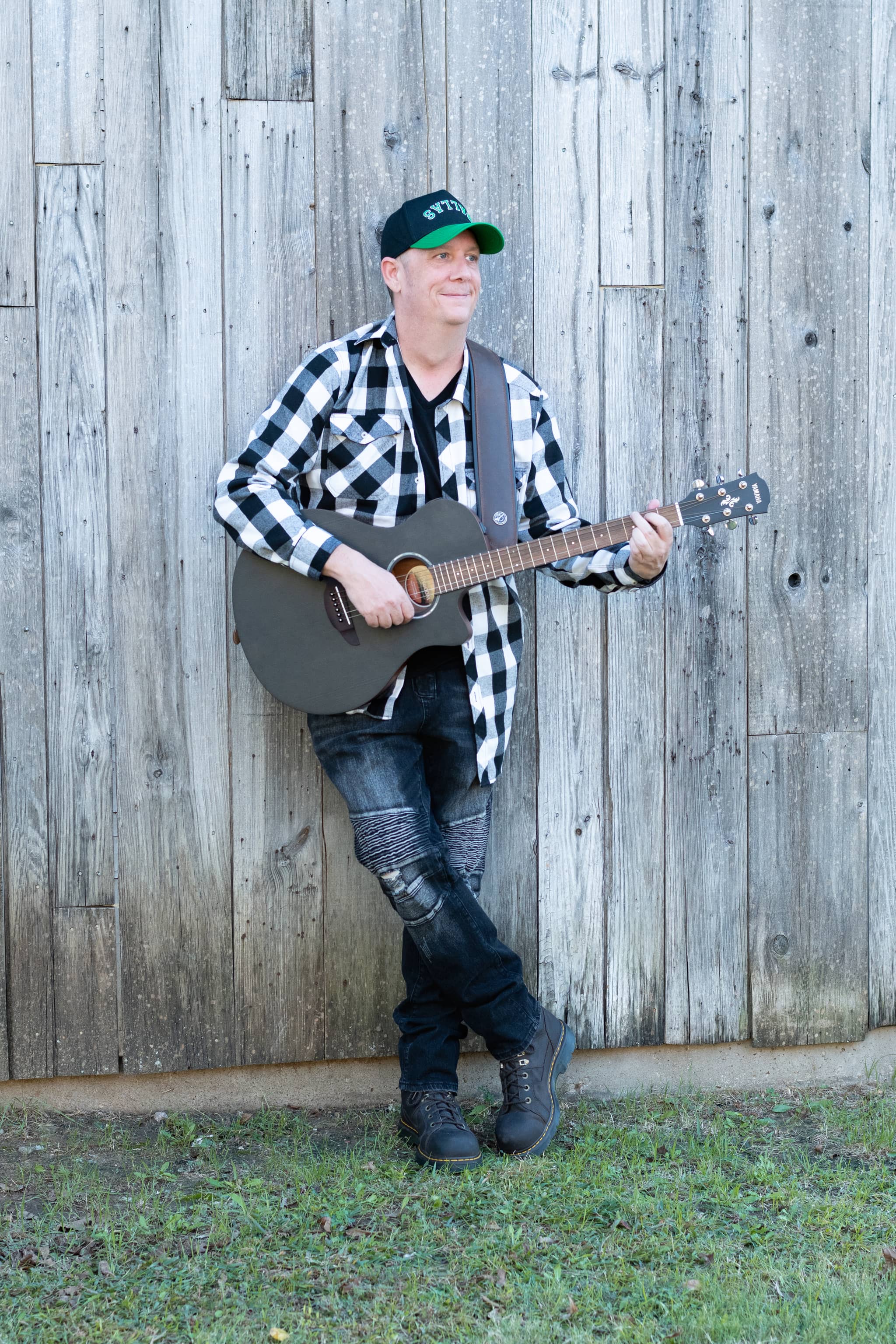 Walker Jackson - Country Music Artist portrait with acoustic guitar against weathered wood background